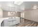 Kitchen and living area with white cabinets, stainless steel appliances, and wood look flooring at 3732 E Greenway Ln, Phoenix, AZ 85032