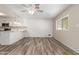 Open concept featuring a modern kitchen and a large living area with wood-look flooring and white walls at 3732 E Greenway Ln, Phoenix, AZ 85032
