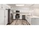 Updated kitchen with stainless steel appliances, white cabinetry and wood flooring at 3732 E Greenway Ln, Phoenix, AZ 85032