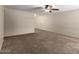 Neutral living room with carpet flooring, ceiling fan, and white trim at 3732 E Greenway Ln, Phoenix, AZ 85032