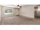 Neutral living room with carpet flooring, a ceiling fan, and a large window letting in natural light at 3732 E Greenway Ln, Phoenix, AZ 85032