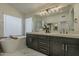 Elegant bathroom with a soaking tub, marble flooring and double vanity sinks with modern fixtures at 3802 W Sheffield Ave, Chandler, AZ 85226