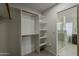 Large walk-in closet with custom shelving adjacent to a bathroom with a glass shower at 3802 W Sheffield Ave, Chandler, AZ 85226