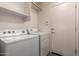 Functional laundry room equipped with modern washer and dryer units, plus extra storage at 41227 W Granada Dr, Maricopa, AZ 85138