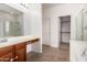 Bright main bathroom with double vanity, frameless shower, soaking tub, and walk-in closet at 41227 W Granada Dr, Maricopa, AZ 85138