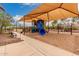 A shaded playground with a variety of climbing and sliding structures for active  at 41227 W Granada Dr, Maricopa, AZ 85138