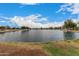 Scenic pond view with lush landscaping and blue skies, perfect for outdoor relaxation at 41227 W Granada Dr, Maricopa, AZ 85138