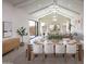 Formal dining room with a long wood table, white chairs, modern light fixture, and open concept living at 42084 N Golden Trl, San Tan Valley, AZ 85140
