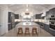 Beautiful kitchen with gray cabinets, stainless steel appliances, an island with seating, and modern lighting at 42084 N Golden Trl, San Tan Valley, AZ 85140