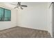 Bright bedroom with a ceiling fan, window, and closet featuring neutral-toned carpet and crisp white walls at 4718 E Decatur St, Mesa, AZ 85205