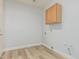 An interior view of a laundry room with laminate wood-look floors and light wood cabinets at 4718 E Decatur St, Mesa, AZ 85205