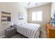 This bedroom features natural light, a comfortable queen-sized bed, and a gray and wood dresser at 5208 S Gold Leaf Pl, Chandler, AZ 85249