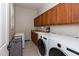 This laundry room features lots of storage space, a folding table, and a washer and dryer at 5208 S Gold Leaf Pl, Chandler, AZ 85249