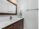Modern half-bathroom with wood vanity, updated faucet, and white walls at 5215 W Del Rio St, Chandler, AZ 85226