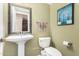 Cozy powder room featuring a pedestal sink, toilet, and decorative art at 5215 W Del Rio St, Chandler, AZ 85226
