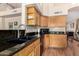 Charming kitchen featuring sleek black sink, granite countertops, and light wood cabinetry at 5215 W Del Rio St, Chandler, AZ 85226