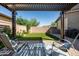 Inviting backyard patio with a pergola, comfortable seating, and a well-manicured lawn at 5616 S Caisson Way, Mesa, AZ 85212