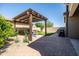 A charming backyard patio features a pergola, comfortable seating, and lush landscaping at 5616 S Caisson Way, Mesa, AZ 85212