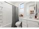 This bathroom features a shower-tub combo, bright natural light, and a modern vanity with white marble counters at 5616 S Caisson Way, Mesa, AZ 85212