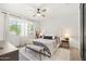 Bright bedroom with a ceiling fan, white walls, and a large window with sheer curtains at 5616 S Caisson Way, Mesa, AZ 85212