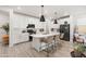 Modern kitchen with white cabinets, quartz countertops, and a stylish island with seating at 5616 S Caisson Way, Mesa, AZ 85212