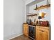 Cozy bar area with wooden shelves, a mini-fridge, and stylish decor at 5909 W Blue Sky Dr, Phoenix, AZ 85083