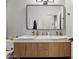 A luxurious bathroom with dual sinks, wooden cabinets, and a stylishly framed mirror at 5909 W Blue Sky Dr, Phoenix, AZ 85083