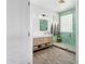 Stylish bathroom with a modern vanity, green tiled shower, and sleek fixtures at 5909 W Blue Sky Dr, Phoenix, AZ 85083