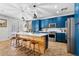 Stylish kitchen boasts blue cabinets, stainless steel appliances, a central island, and pendant lighting at 5909 W Blue Sky Dr, Phoenix, AZ 85083