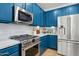Contemporary kitchen with blue cabinetry, marble countertops, and stainless steel appliances at 5909 W Blue Sky Dr, Phoenix, AZ 85083