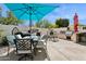 This outdoor kitchen and dining area is shaded by a brilliant blue umbrella at 5909 W Blue Sky Dr, Phoenix, AZ 85083