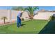 Backyard putting green for practice, surrounded by lush desert landscaping and privacy fencing at 6528 W Brookhart Way, Phoenix, AZ 85083