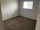 This cozy bedroom features carpeting, neutral walls, and a window allowing natural light at 6624 S Granada Dr, Tempe, AZ 85283