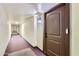 Long hallway with textured walls leading to a brown door marked with '301' and a visible doorbell at 7930 E Camelback Rd # 301, Scottsdale, AZ 85251