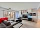 Living room featuring a comfortable gray sofa and entertainment center with a large TV and balcony access at 7930 E Camelback Rd # 301, Scottsdale, AZ 85251