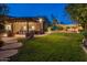 Backyard with outdoor kitchen under covered patio overlooking manicured lawn at 9417 E Charter Oak Dr, Scottsdale, AZ 85260