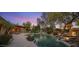 A beautiful backyard offers an outdoor kitchen, pool, waterfall features and professionally landscaped grounds for easy care at 9417 E Charter Oak Dr, Scottsdale, AZ 85260