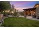 Lush backyard with a covered patio, outdoor kitchen, and beautiful landscaping at 9417 E Charter Oak Dr, Scottsdale, AZ 85260