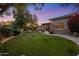 Expansive backyard with lush lawn, stone accents, and beautiful home exterior at 9417 E Charter Oak Dr, Scottsdale, AZ 85260