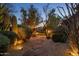 Landscaped backyard with stone pathway and ambient lighting showcasing the property at 9417 E Charter Oak Dr, Scottsdale, AZ 85260