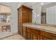 Bathroom with wood cabinets, tile countertops, and a walk-out to the patio at 9417 E Charter Oak Dr, Scottsdale, AZ 85260