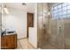 Bathroom featuring a walk-in shower with tile surround and a vanity with a dark countertop at 9417 E Charter Oak Dr, Scottsdale, AZ 85260
