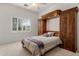 Guest bedroom featuring a full size bed, custom built-ins, and a window with shutters at 9417 E Charter Oak Dr, Scottsdale, AZ 85260