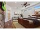 A stylish bedroom with a stone fireplace, wood floors, a ceiling fan, and a sitting area with a couch at 9417 E Charter Oak Dr, Scottsdale, AZ 85260