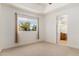 Bright bedroom featuring neutral carpet, a tray ceiling, and a door to an adjacent room at 9417 E Charter Oak Dr, Scottsdale, AZ 85260