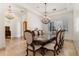 Traditional dining room with a glass-top table, upholstered chairs, a crystal chandelier, and travertine flooring at 9417 E Charter Oak Dr, Scottsdale, AZ 85260
