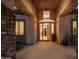 Grand entryway with stone accents, pendant lighting, and a glimpse of the home's interior at 9417 E Charter Oak Dr, Scottsdale, AZ 85260