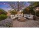 Cozy fire pit area featuring comfortable seating, surrounded by lush landscaping and string lights at 9417 E Charter Oak Dr, Scottsdale, AZ 85260