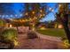Firepit area with built-in seating and string lights for a relaxing atmosphere at 9417 E Charter Oak Dr, Scottsdale, AZ 85260