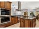 Open concept kitchen with stainless steel appliances, granite countertops and custom cabinetry at 9417 E Charter Oak Dr, Scottsdale, AZ 85260
